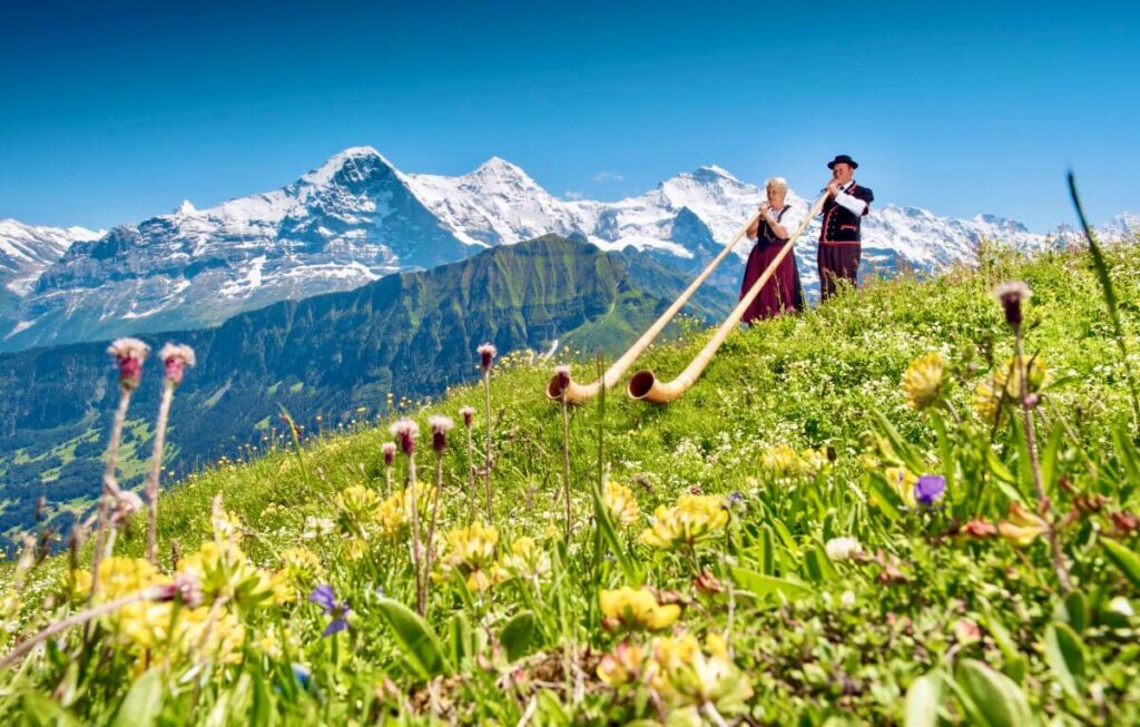 Alphorn players in front of the Eiger, Mönch and Jungfrau